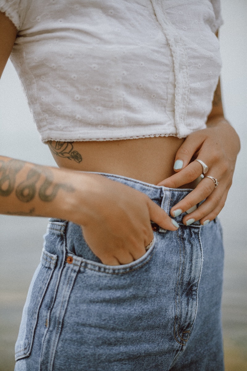 woman in crop top holding her stomach