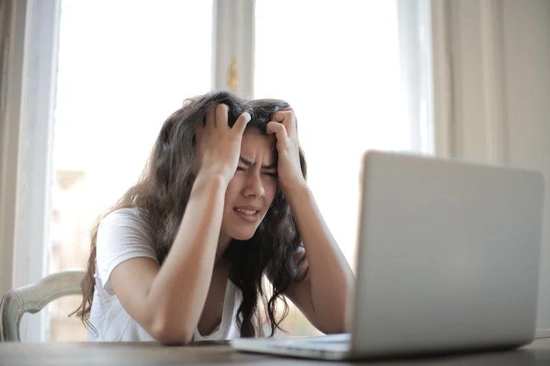 woman sitting in front of computer stressed with messy hair