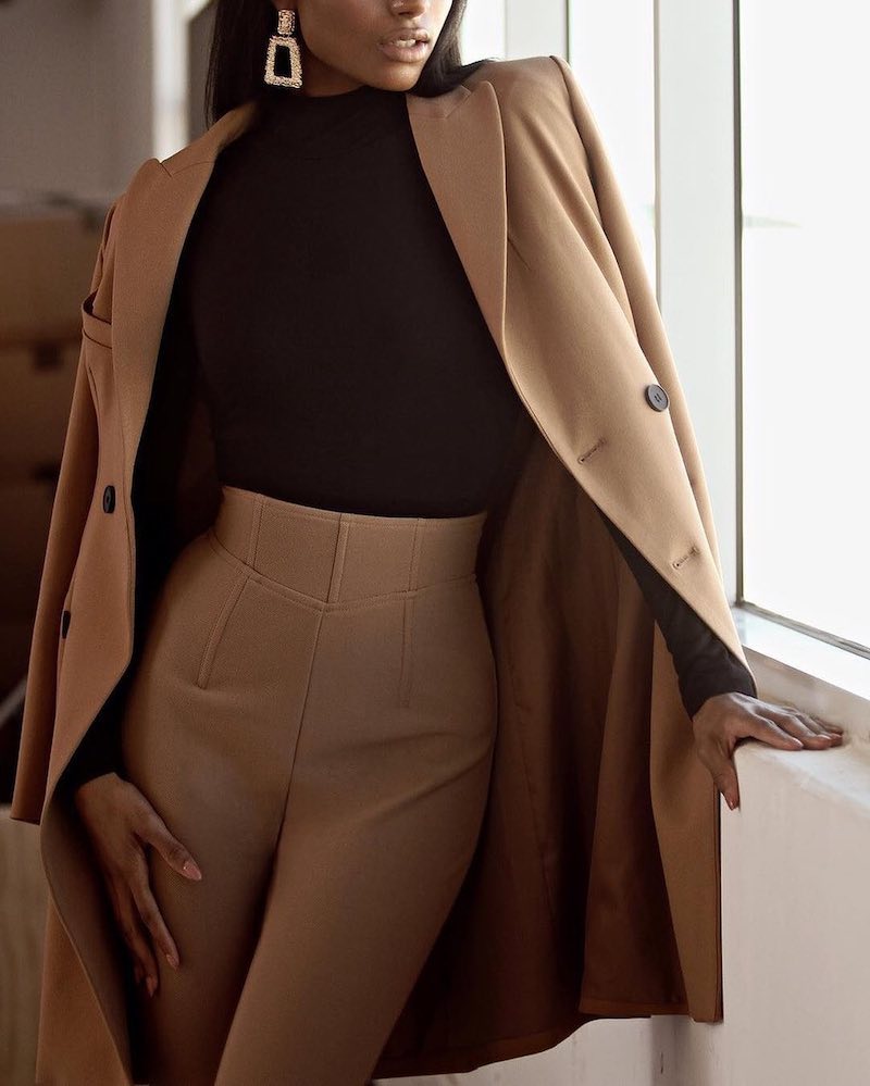 woman with black turtle neck and brown pants and blazer classy