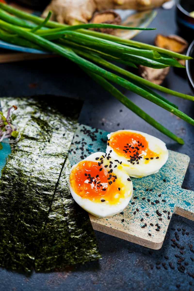 a soft boiled egg halved and topped with sesame seeds