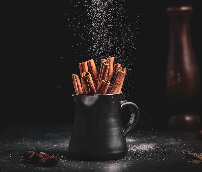 boost your energy cinnamon sticks in a black cup