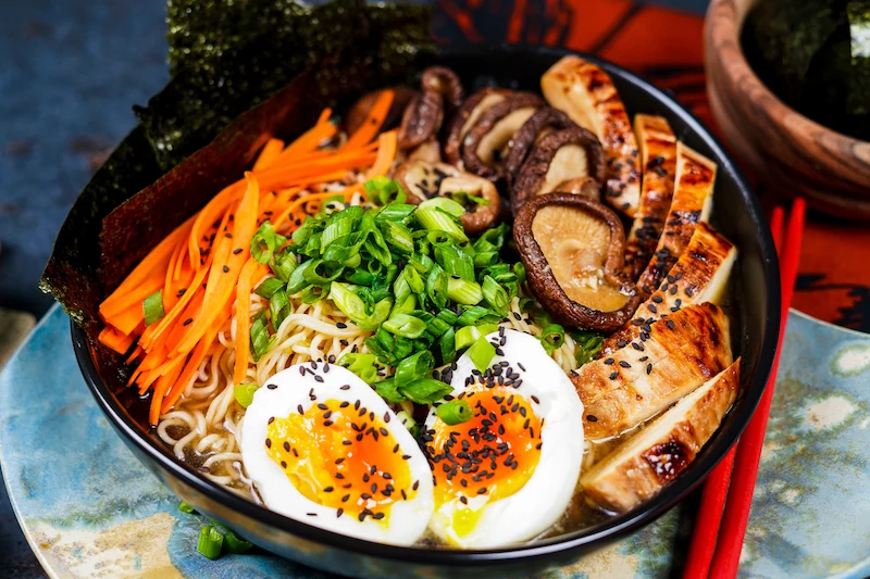 bowl of ramen with mushrooms carrots egg nori