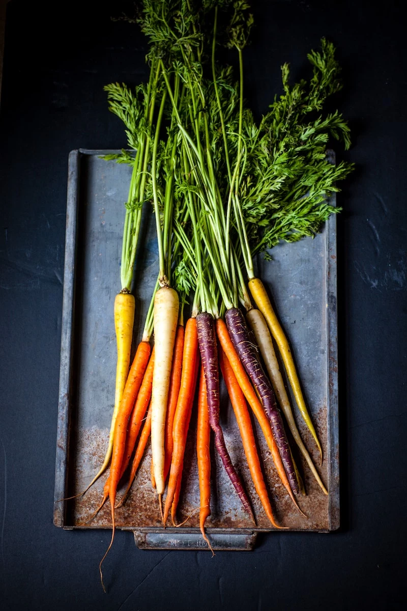 different colored carrots on a sheet pan