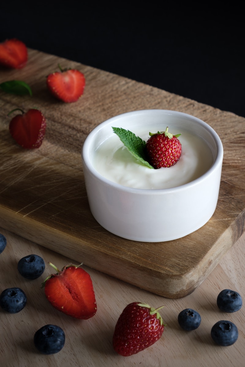 energy boostin foods yogurt in a bowl with strawberries and blueberries