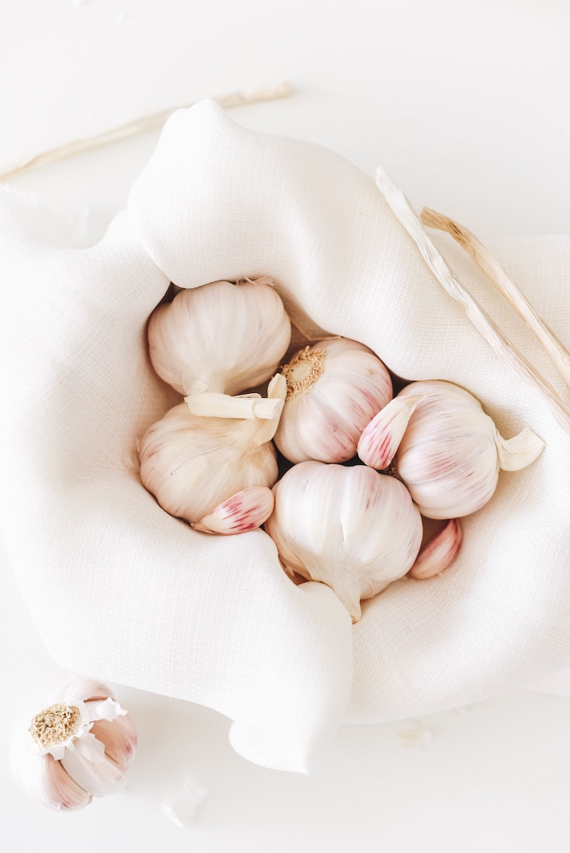 garlic heads in a white cloth on white background