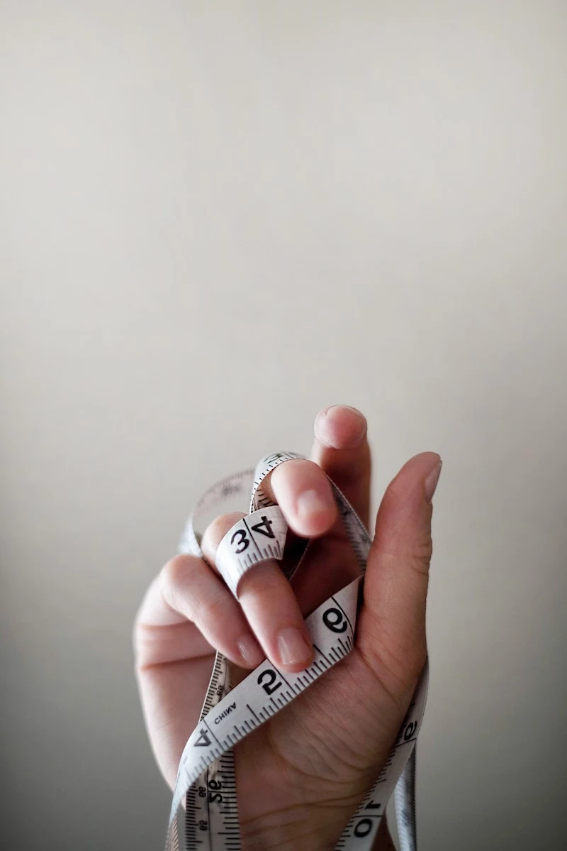 hand tangled in white measuring tape