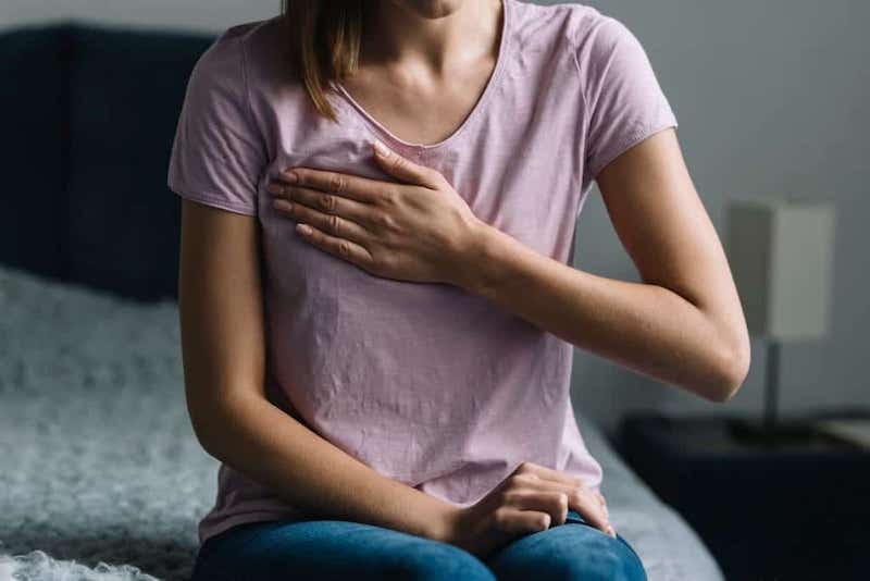 heartburn relief photo of close up woman suffering from chest pain