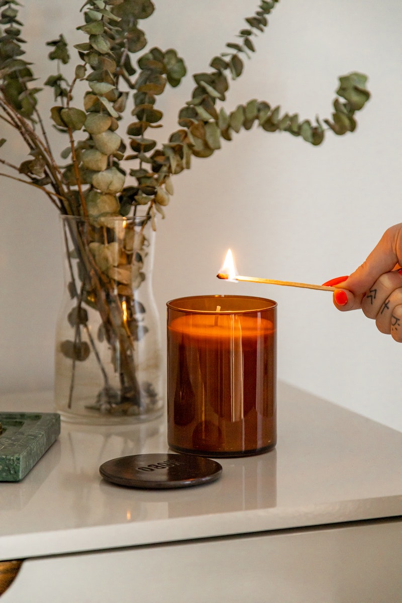 house cleansing lighting an aroma candle with a match stick