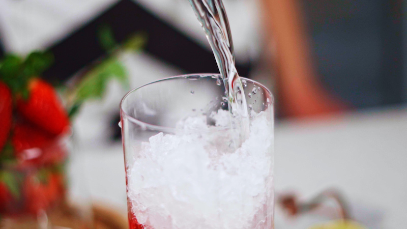 how to make strawberry mojito rum being poured on to crushed ice