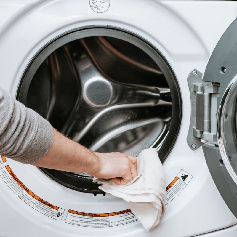man washing washing machine with towel