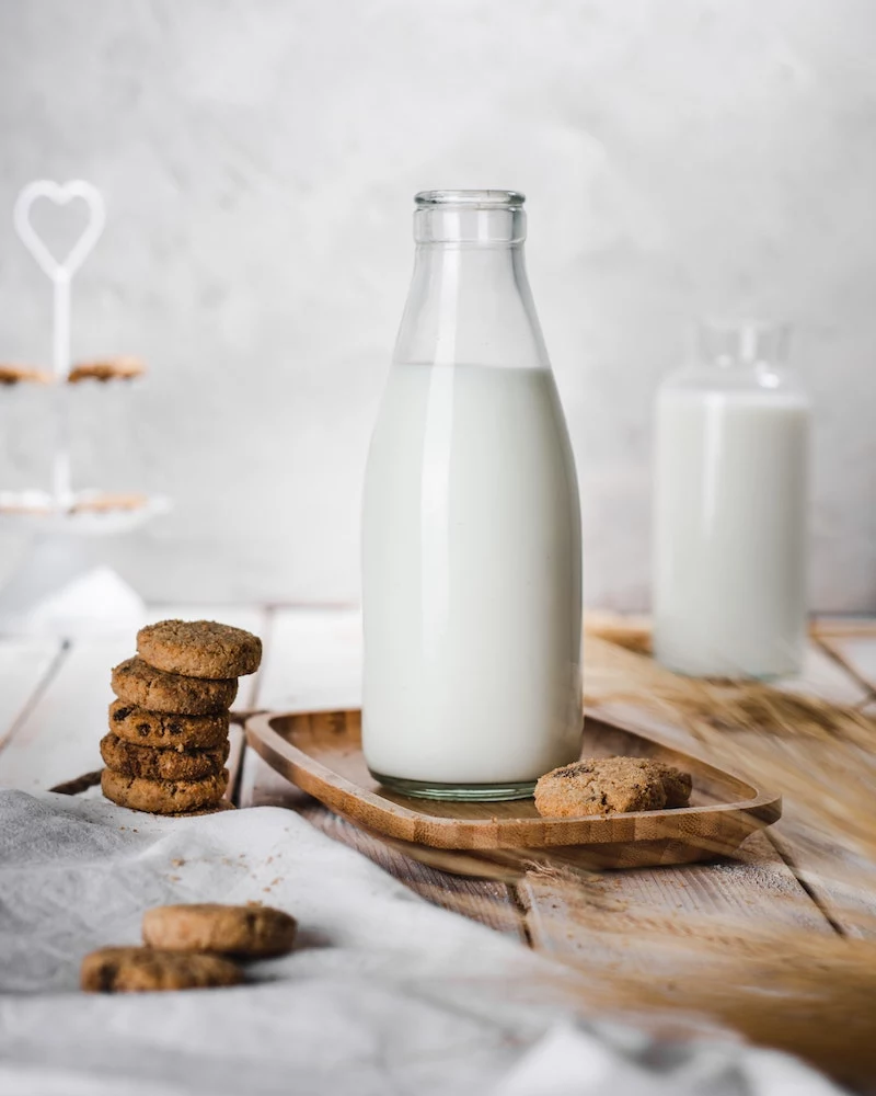 milk in glass bottles next to cookies
