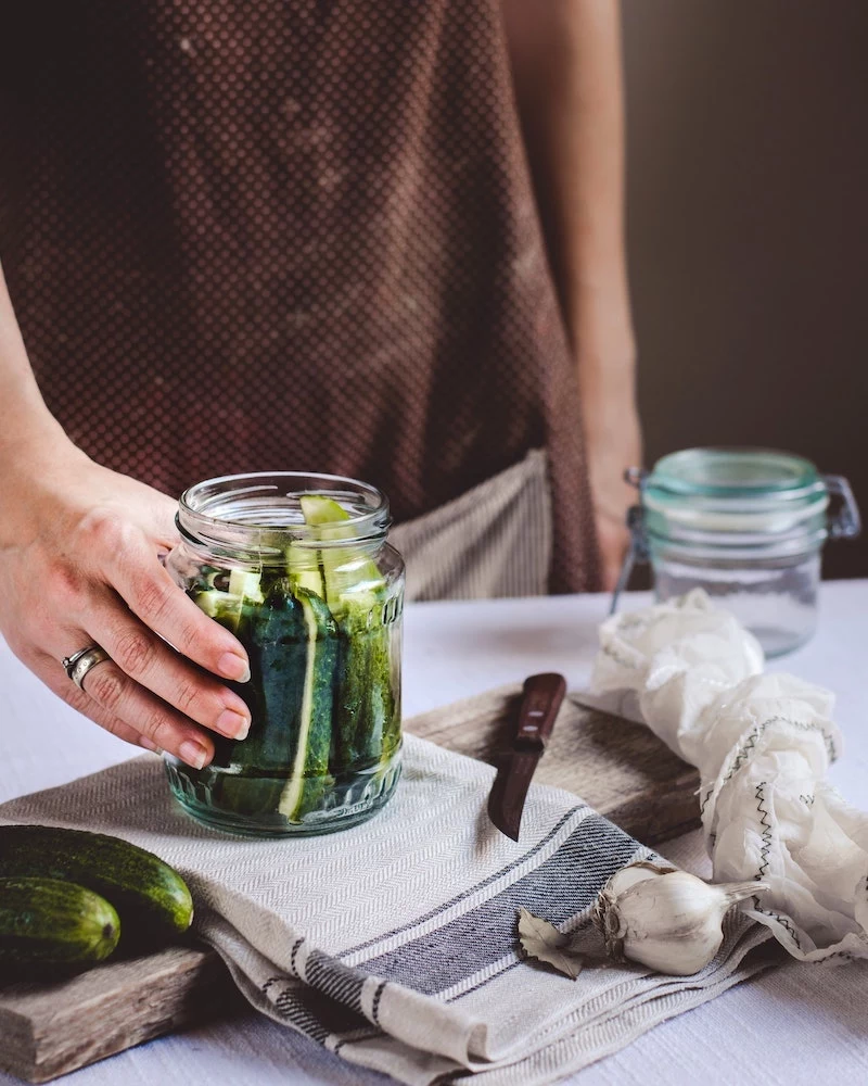 person fermenting their own jar of pickles