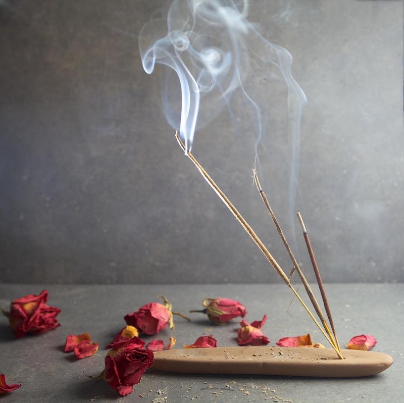 symptoms of negative energy at home lit incense sticks with rose petals