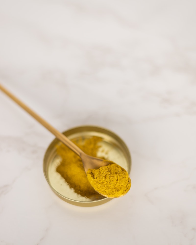 turmeric benefits gold yellow turmeric powder on a spoon
