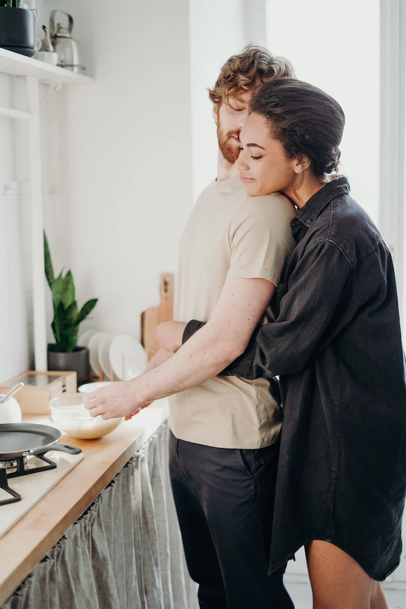 what does maca do to the body woman hugging man from behind as he makes breakfast