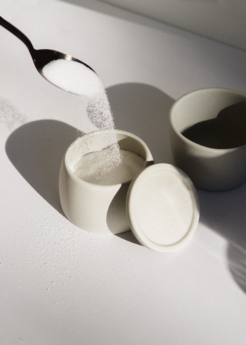 white sugar being poured into a container