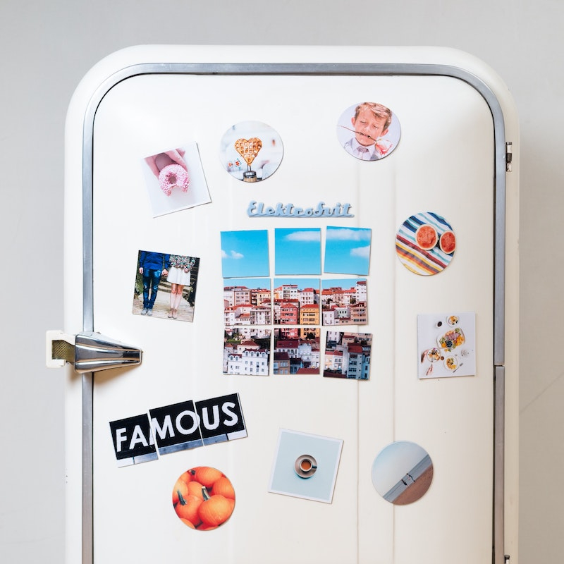 white vintage fridge with magnets and stickers
