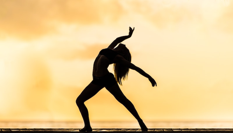 woman doing you yoga in front of the sunset