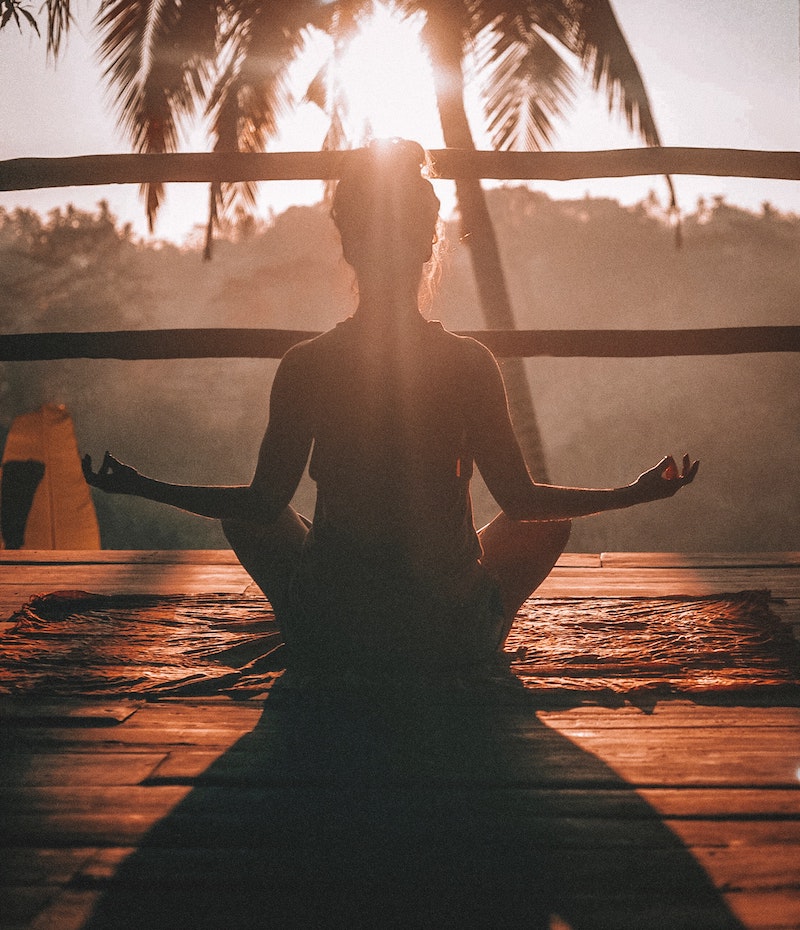 woman practicing yoga in the sunset