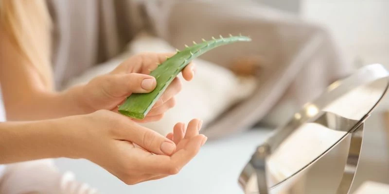 woman putting aloe vera on her hand