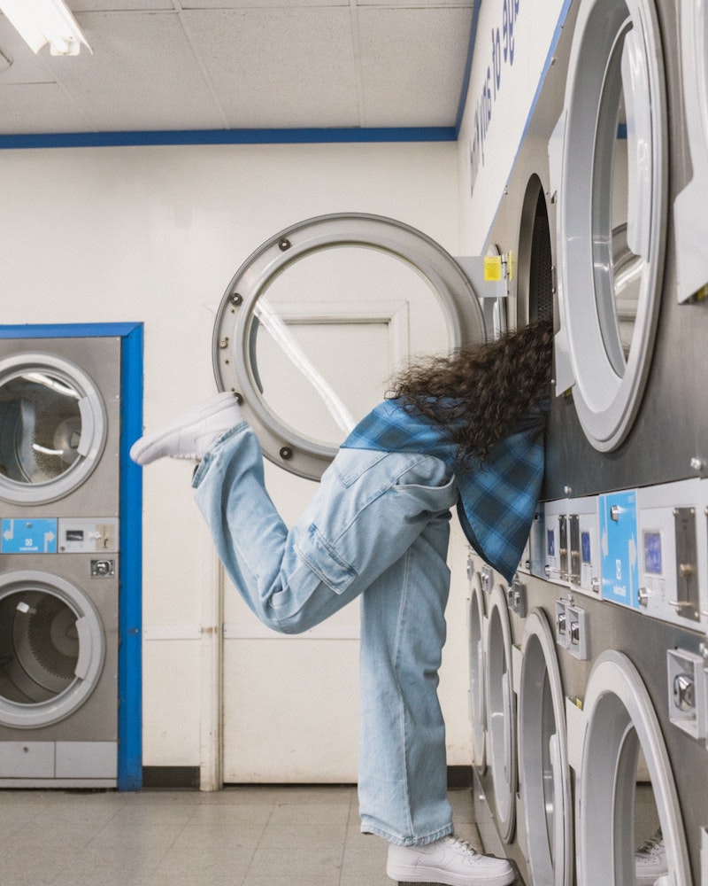 woman with blue jeans in a washing machine