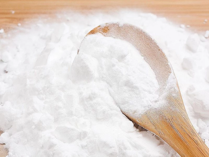 baking soda spilled on table with wooden spoon