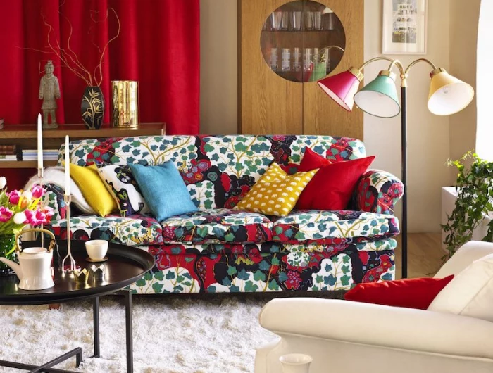 colorful couch with red drapes behind and tri colored lamps