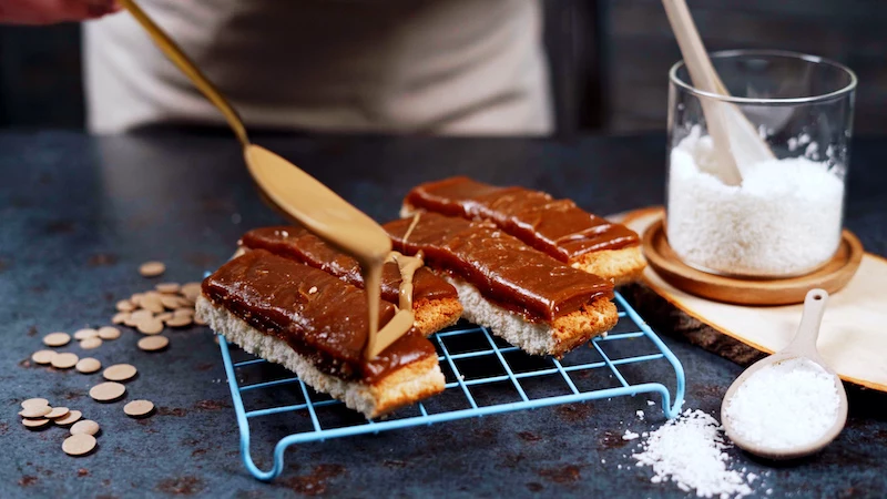 drizzling chocolate on homemade twix bars