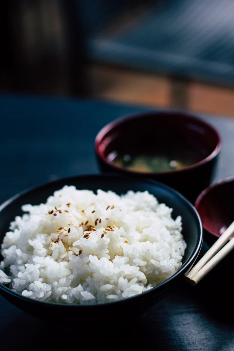 foods to help you sleep better white rice in a black bowl