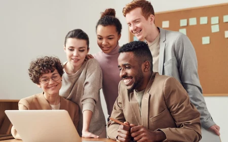 group of team members gathered around the laptop