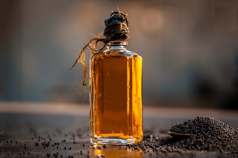 close,up,of,brown,mustard,seed,with,its,extracted,oil,on