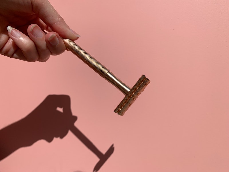razor being held on pink background
