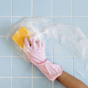 scrubbing blue tiles with yellow sponge