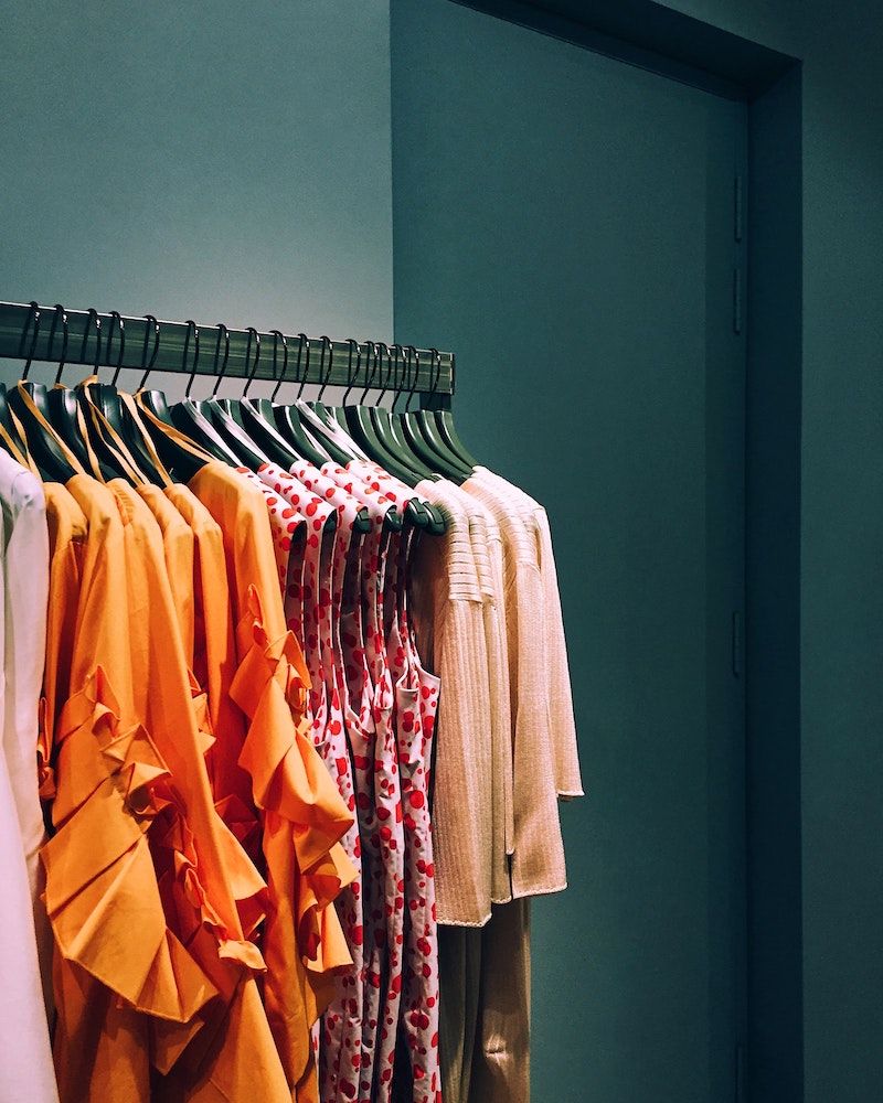 summer wardrobe clothes hanging on a rack