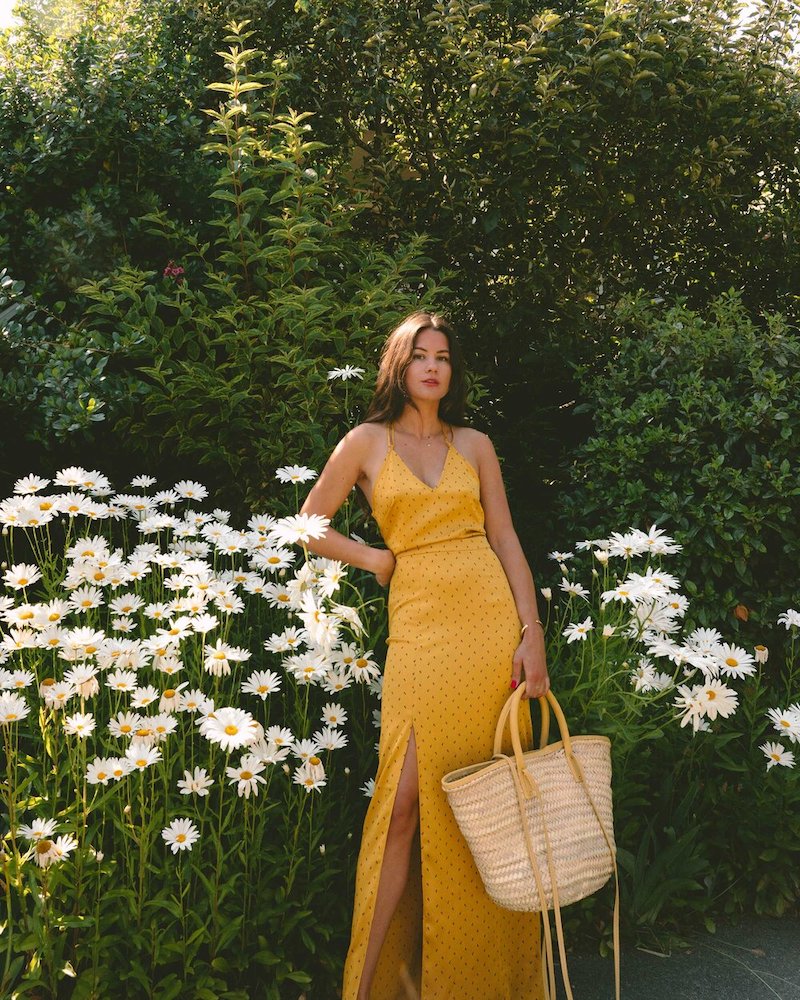 easy summer outfit idea. sarah butler of @sarahchristine wearing bcbg yellow satin polka dot skirt and yellow satin tank top with jacquemus le panier soleil woven straw tote bag in seattle, washington.