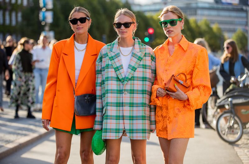 three women two with bright orange blazers