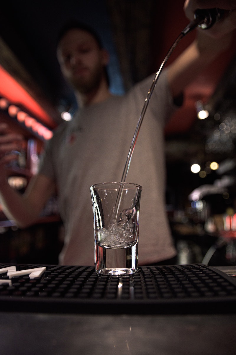 Wodka wordt in een borrelglas gegoten