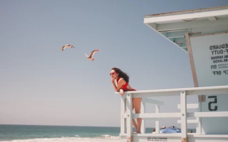 woman lifeguard with red swimsuit on wooden deck