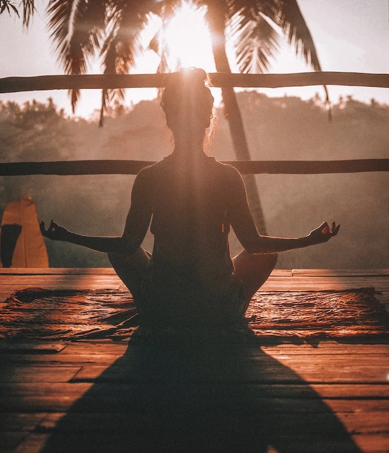 woman meditating in the sunset