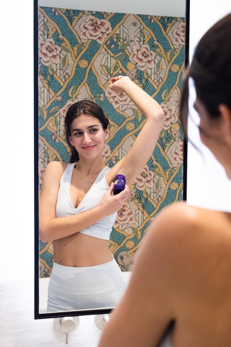 woman putting on antipersipirant in the0mirror