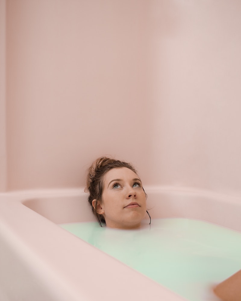 woman soaking in bathtub with pink color