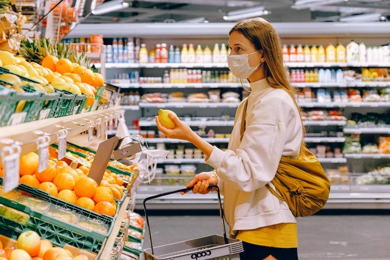 woman with mask on grocery shopping