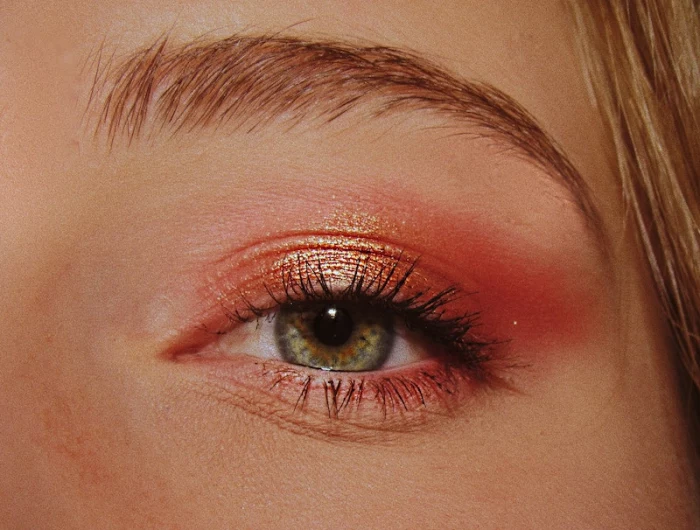 womans green eye with pink eyeshadow
