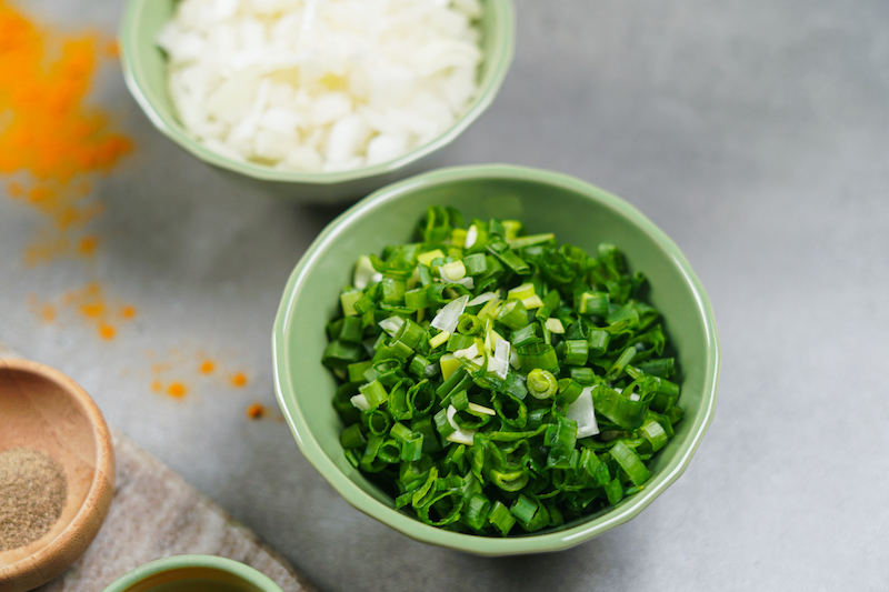 chopped green onions and onion in two bowls