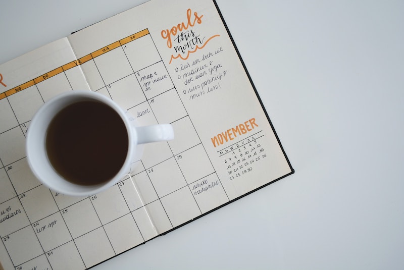 cup of coffee on a journal with calendar