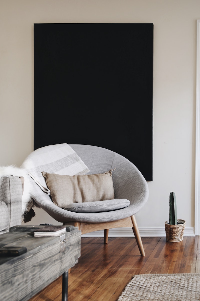 gray chair with black painting on wall