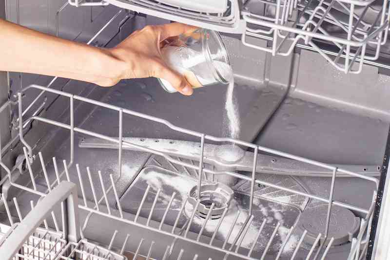 how to clean the dishwasher baking soda being poured into dishwasher