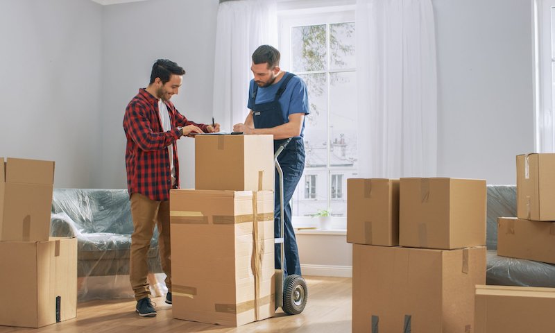 how to move heavy furniture man surrounded by boxes