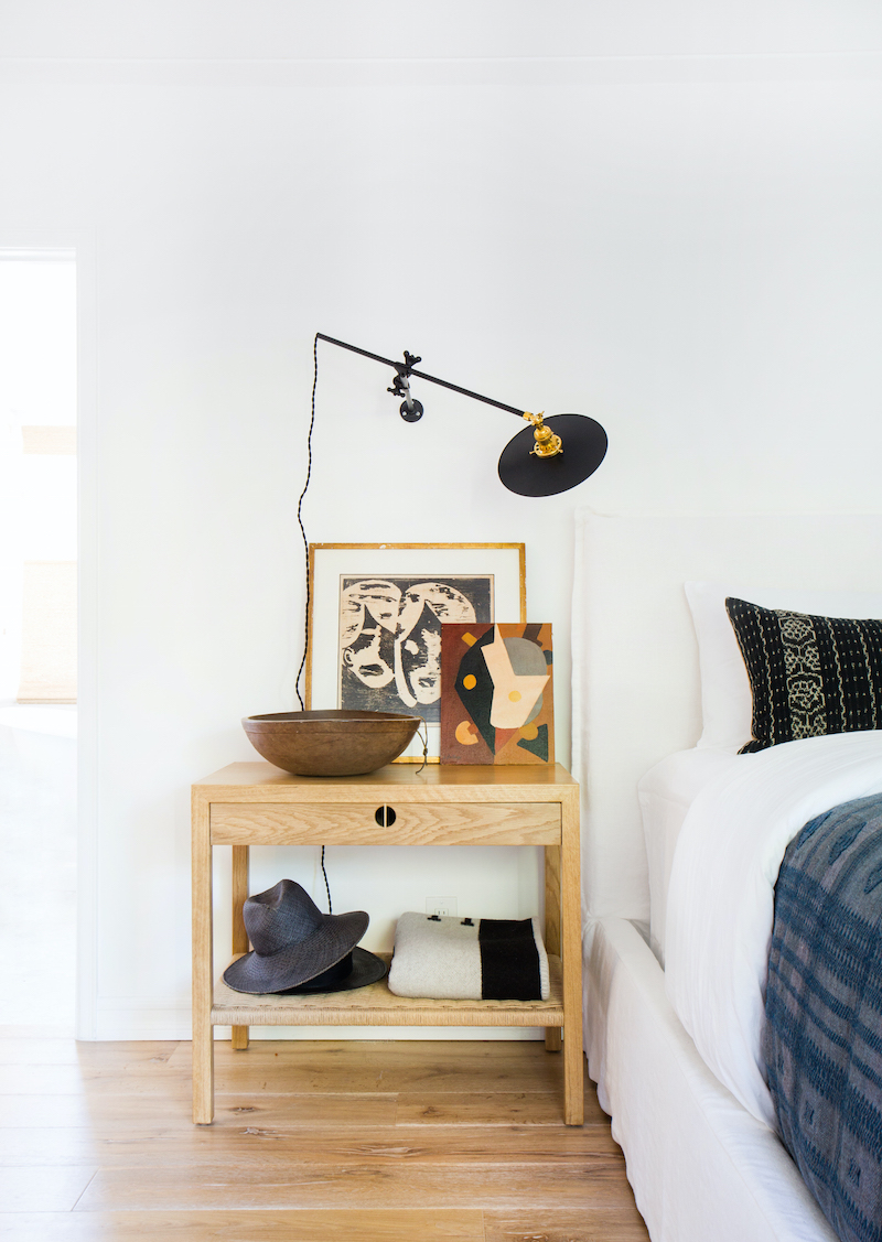 Make your bedroom look expensive with a large wooden bowl lamp and a painting