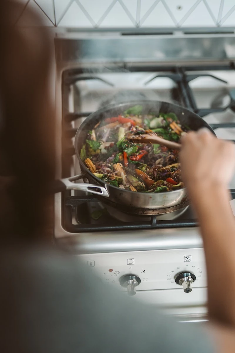 person cooking a meal on the stove top